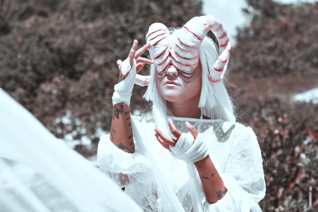 Surreal fantasy portrait featuring a person in a horned costume with a white outfit in an outdoor setting.